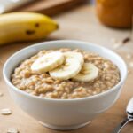 "Baked banana oatmeal in a white tray with fresh ingredients"