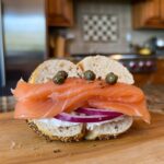 Mediterranean-inspired smoked salmon bagel with olives and sun-dried tomatoes.