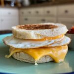 Egg and cheese breakfast sandwich variations on a serving board.